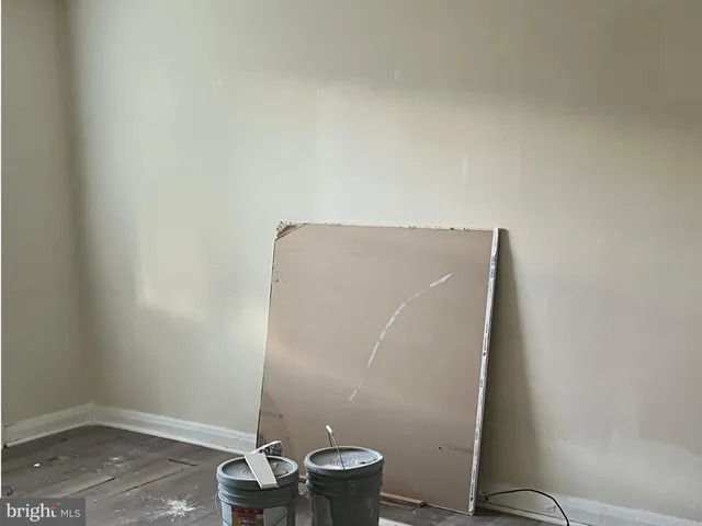 an empty room with a potted plant and a window