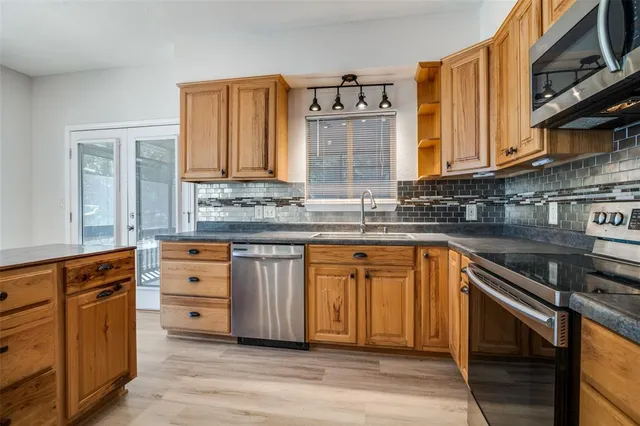 a kitchen with stainless steel appliances granite countertop a sink stove and cabinets