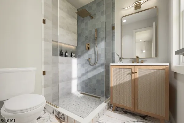 a bathroom with a granite countertop sink a toilet a mirror and shower