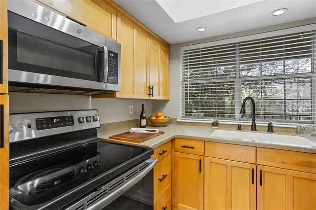 a kitchen with stainless steel appliances granite countertop a refrigerator a sink and a cabinets
