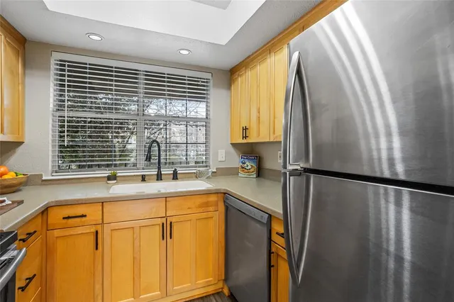 a view of an empty room with wooden floor fireplace and a window