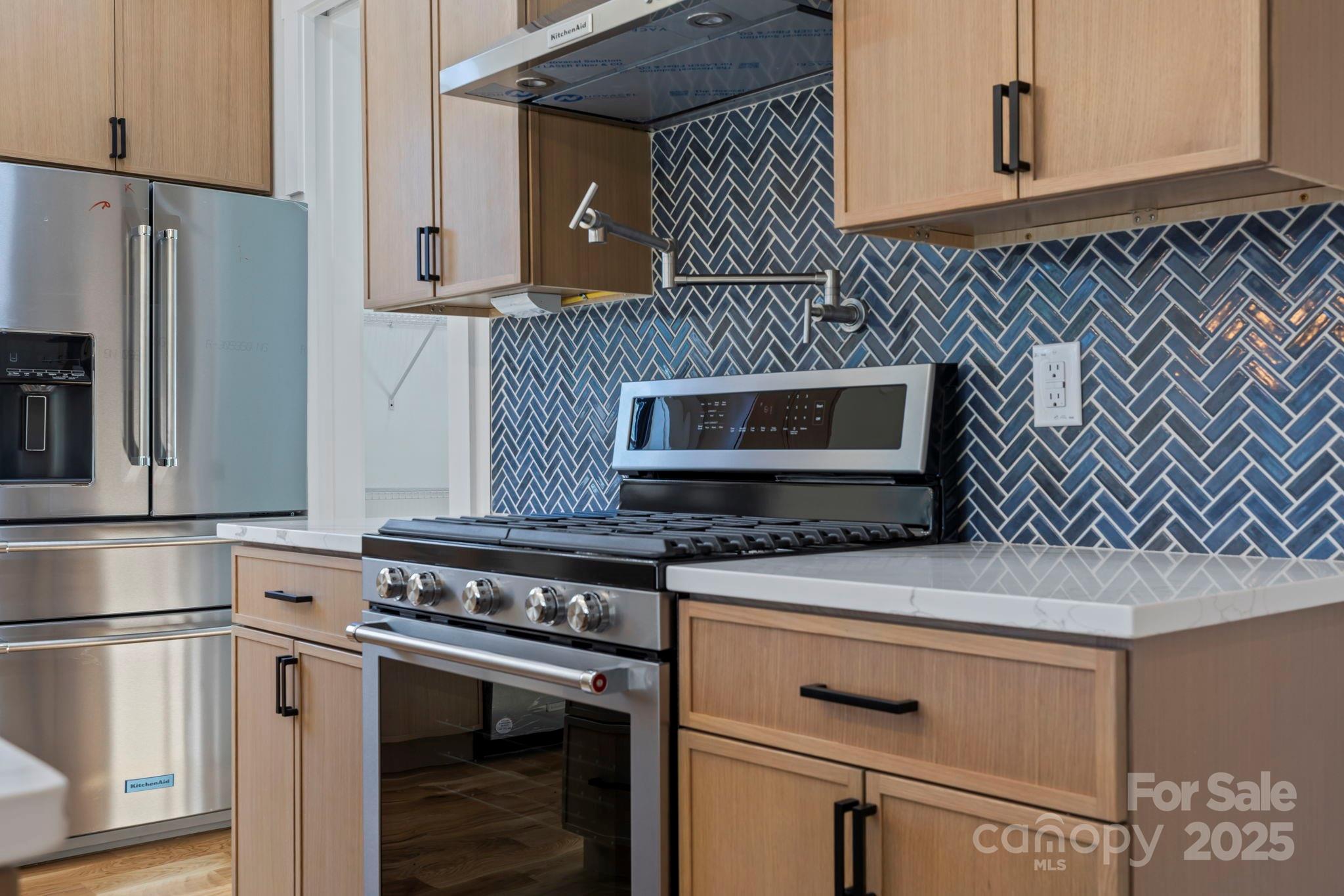 154 Osceola Road Hendersonville, NC 28739 - Photo 21 of 38 a kitchen with granite countertop cabinets stainless steel appliances and wooden floor