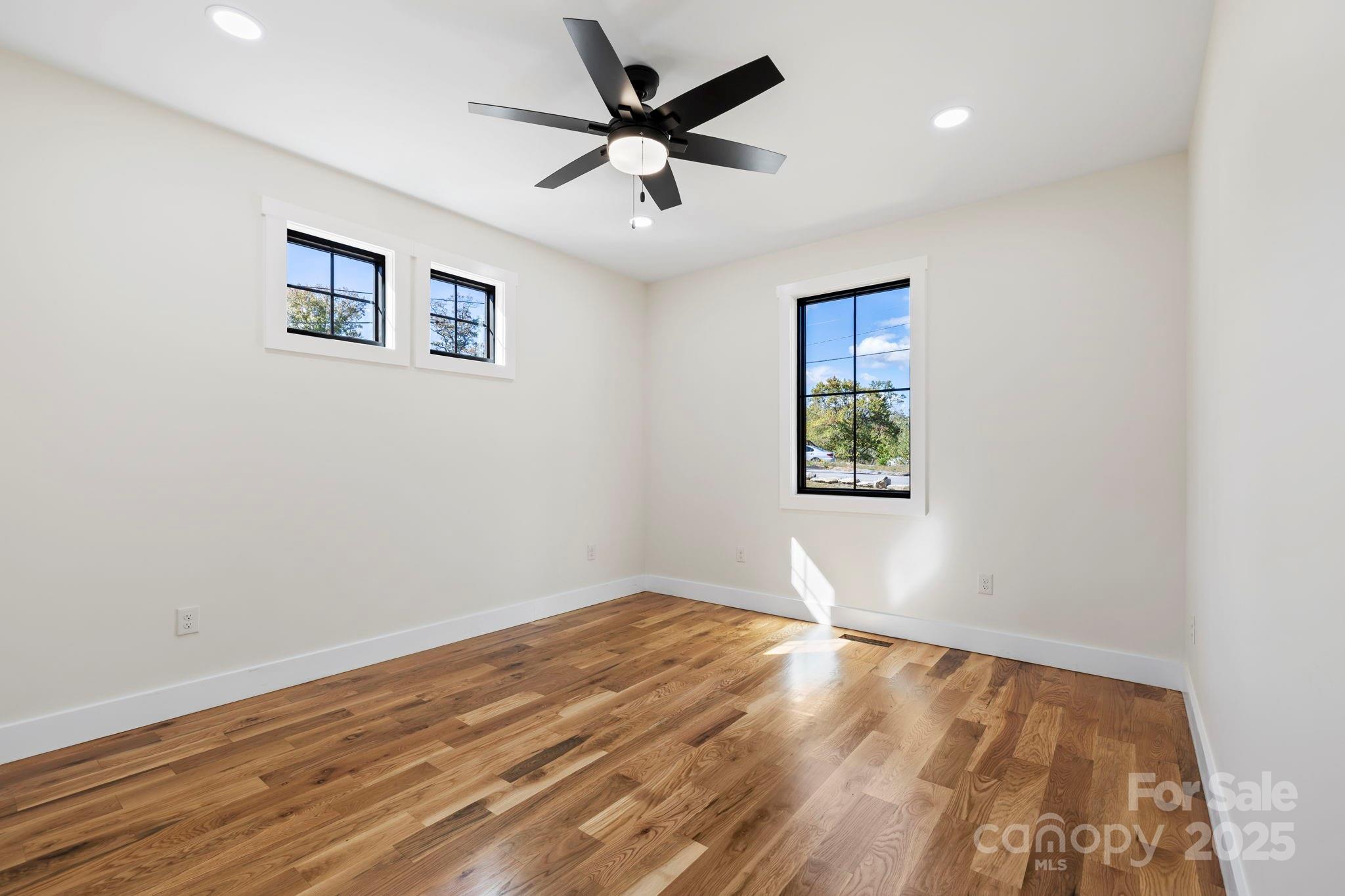 154 Osceola Road Hendersonville, NC 28739 - Photo 24 of 38 an empty room with wooden floor and windows
