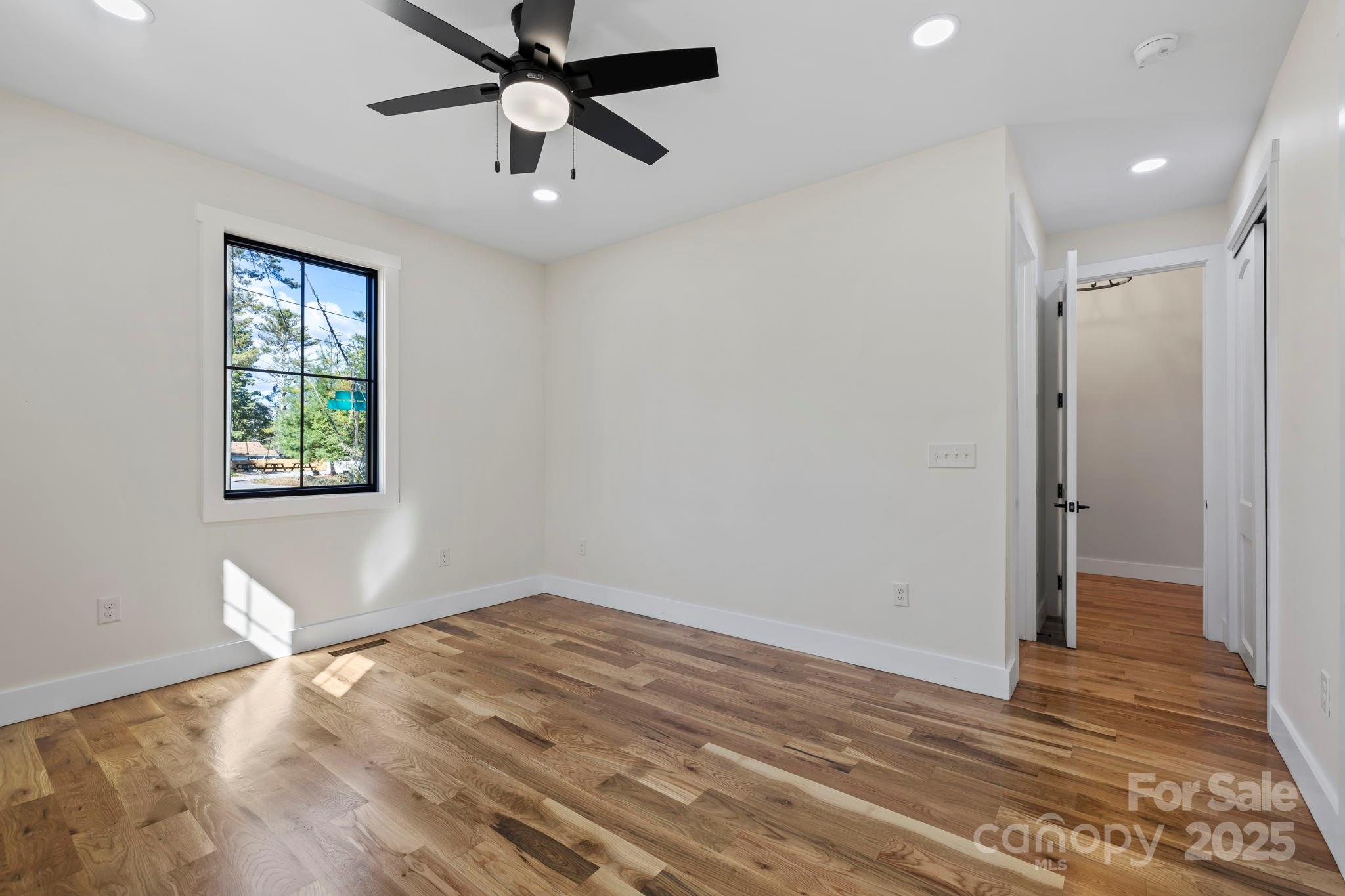 154 Osceola Road Hendersonville, NC 28739 - Photo 25 of 38 a view of empty room with wooden floor and fan