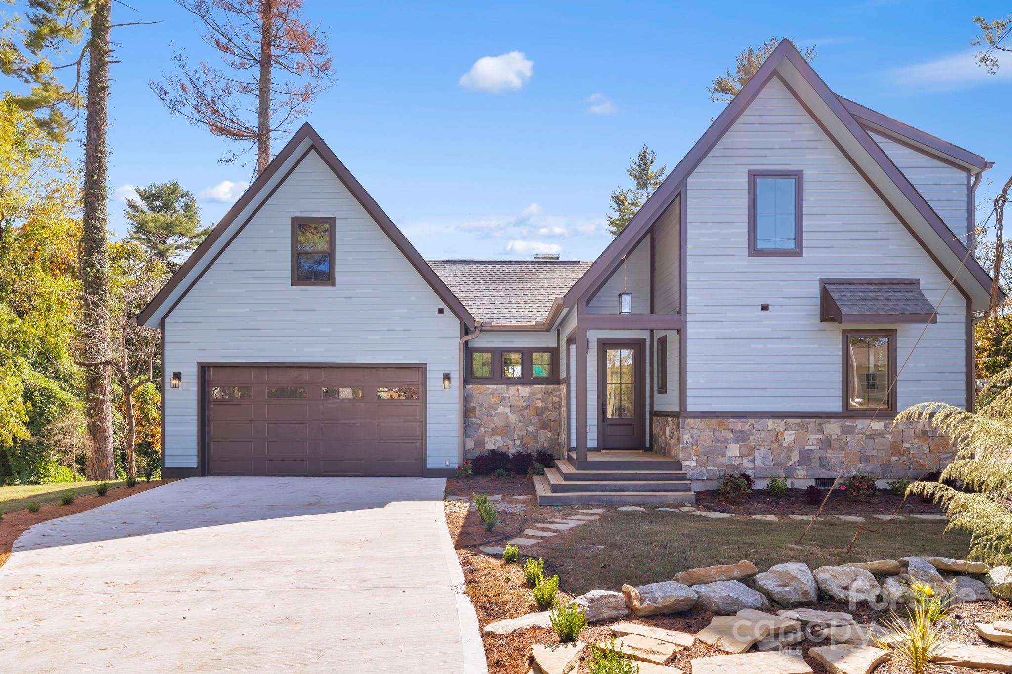 154 Osceola Road Hendersonville, NC 28739 - Photo 3 of 38 a front view of a house with a yard and garage