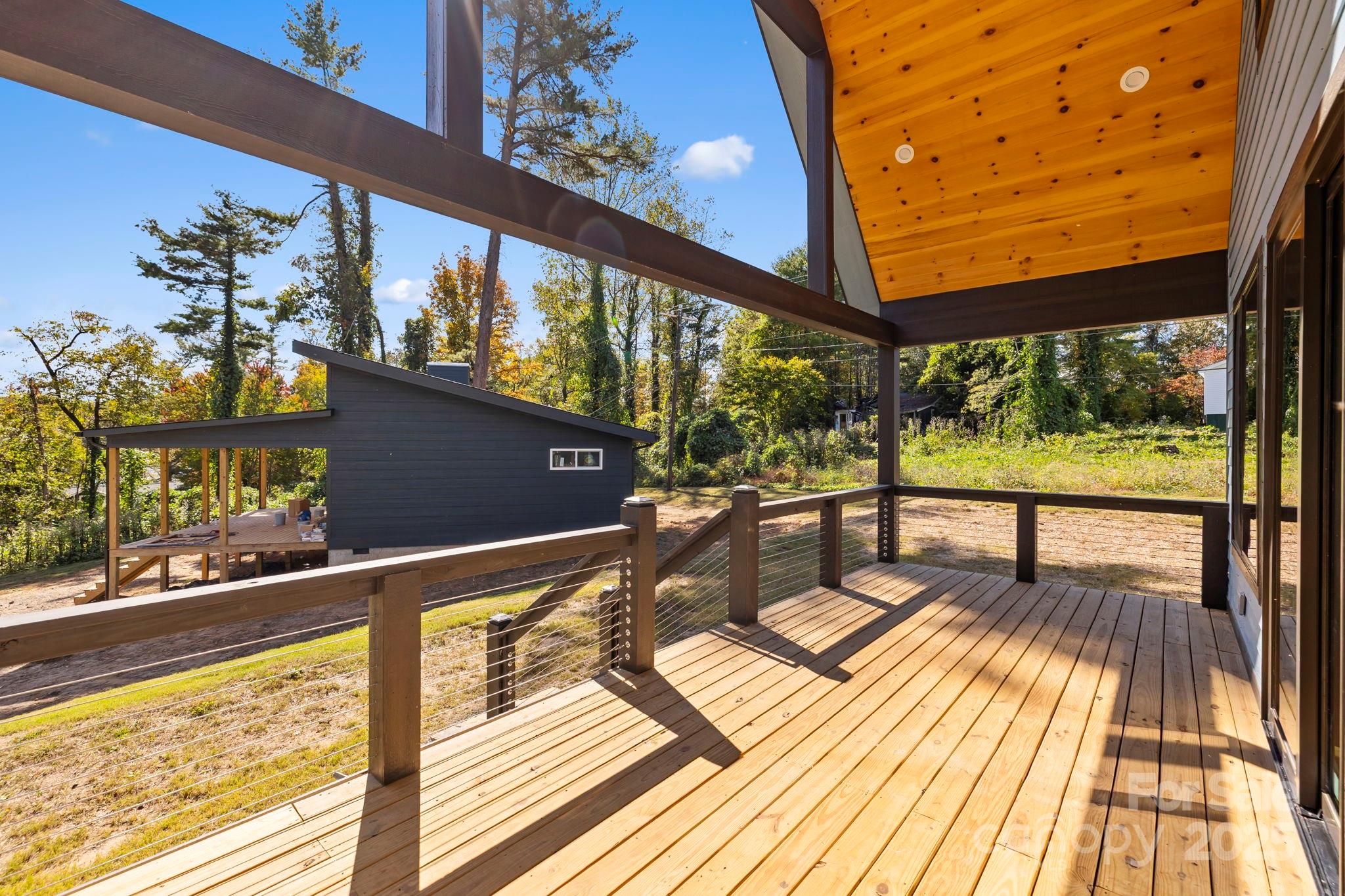 154 Osceola Road Hendersonville, NC 28739 - Photo 9 of 38 a view of a balcony with chairs and wooden floor