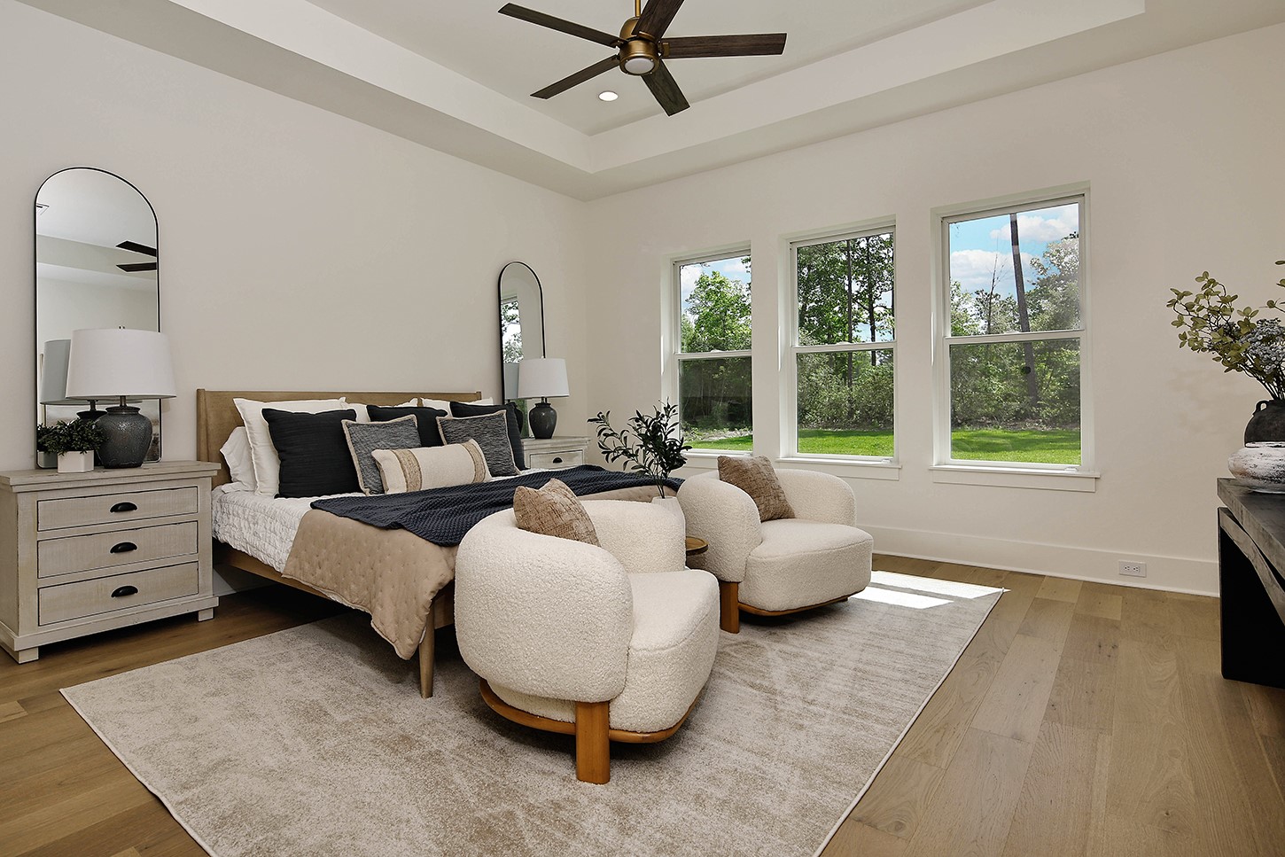 15728 Woodlife Road Willis, TX 77378 - Photo 21 of 36 Primary bedroom is spacious with elevated feel in recessed ceiling detail, window wall with beautiful outdoor views, and french oak wood floors. Expansive walk-in closet another great feature.