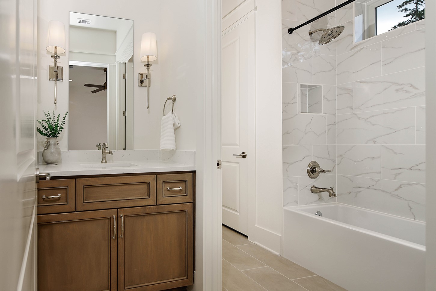 15728 Woodlife Road Willis, TX 77378 - Photo 28 of 36 Bathroom 2 is a Jack and Jill layout shared between both bedrooms. Separate wood-stained vanities with silver fixtures and a stylish and upscale atmosphere. Shared tub/shower/toilet area.