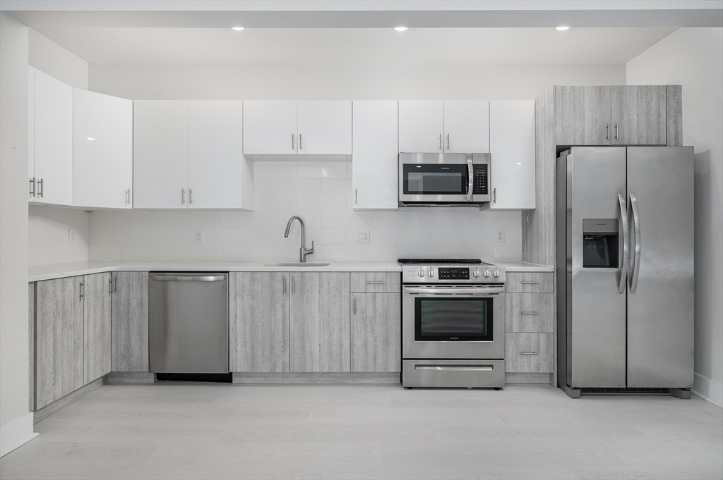 a kitchen with cabinets and stainless steel appliances