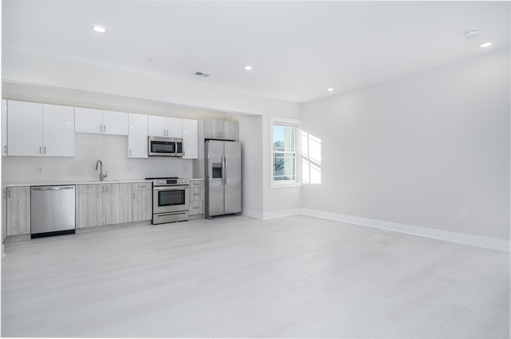 1540 North Shore Road, Unit 302 Revere, MA 02151 - Photo 2 of 15 a kitchen with stainless steel appliances a refrigerator and white cabinets