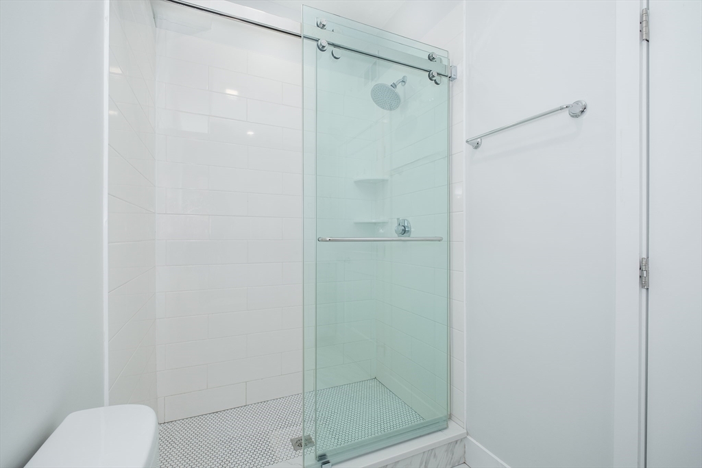 1540 North Shore Road, Unit 302 Revere, MA 02151 - Photo 5 of 15 a bathroom with a shower and toilet
