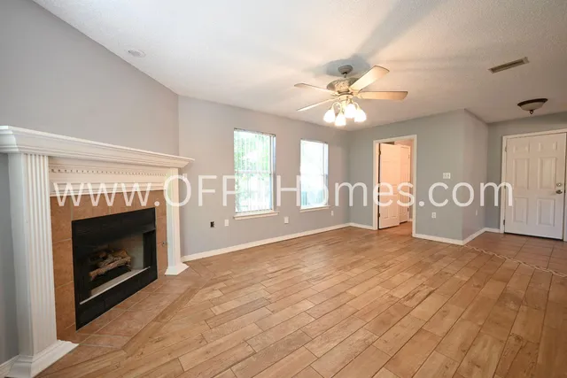 a view of an empty room with window and fireplace