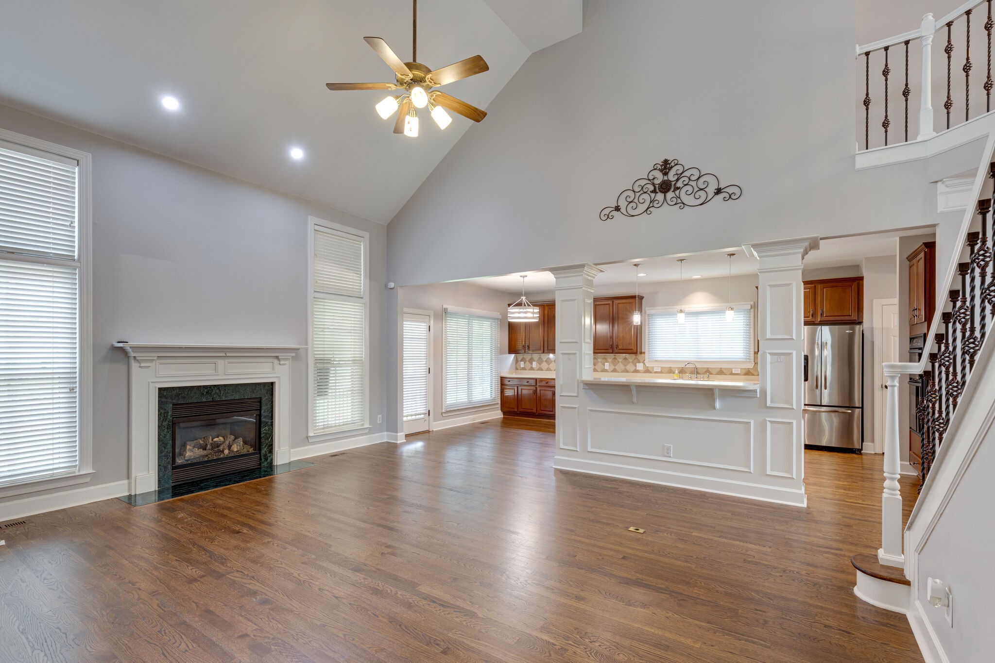 119 Richards Glen Drive Franklin, TN 37067 - Photo 6 of 41 an empty room with wooden floor a fireplace and a kitchen