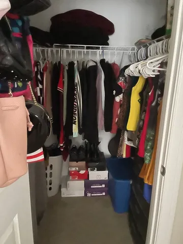 a view of walk in closet with clothes and shoes
