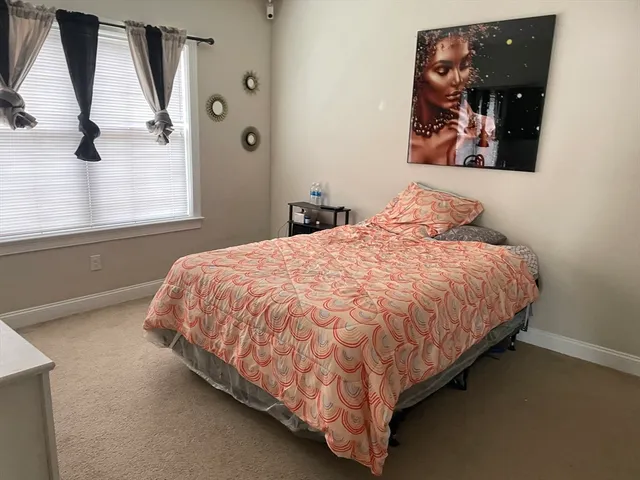 a bed sitting in a bedroom next to a window