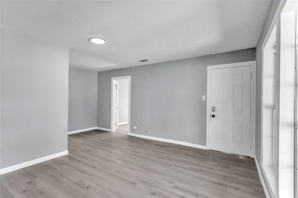 a view of an empty room with wooden floor