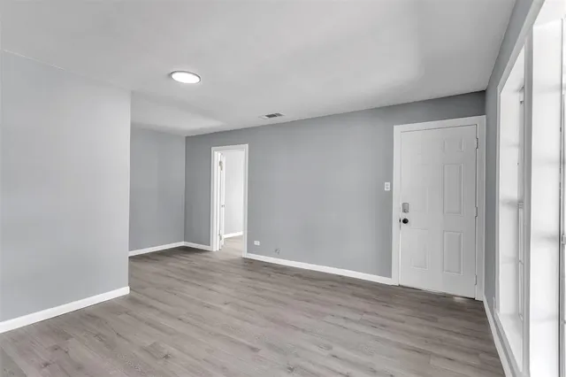 a view of an empty room with wooden floor