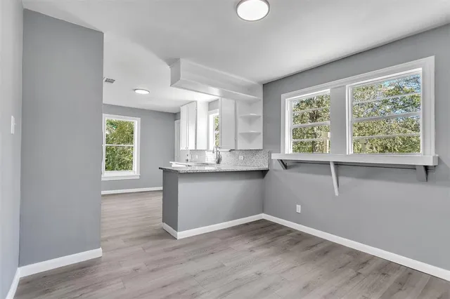 a view of a kitchen with wooden floor and a window