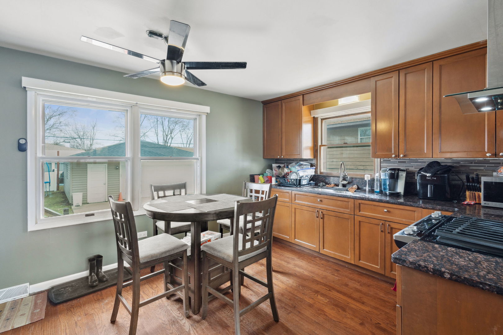3116 191st Place Lansing, IL 60438 - Photo 6 of 19 a kitchen with stainless steel appliances granite countertop a stove a sink dishwasher a dining table and chairs with wooden floor