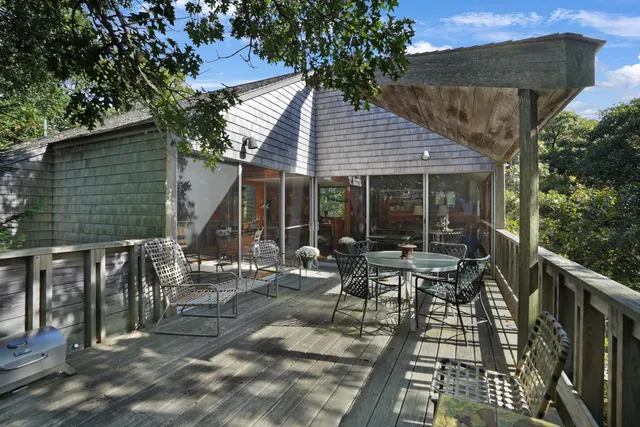 a view of a patio with table and chairs and wooden floor