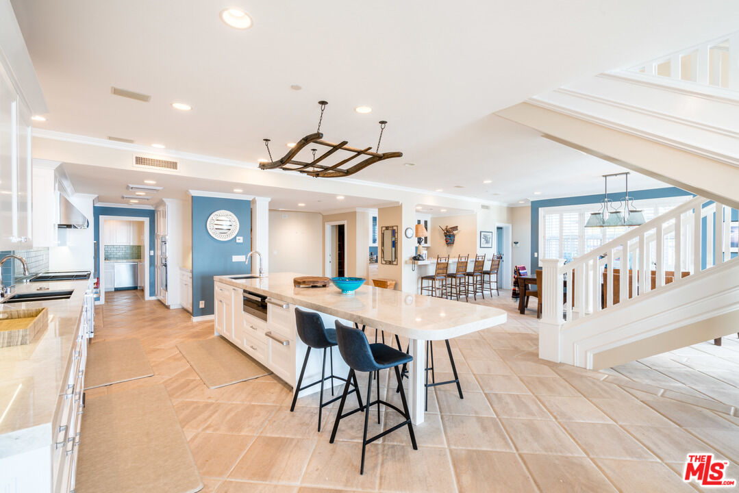 31444 Broad Beach Road Malibu, CA 90265 - Photo 8 of 36 a large white kitchen with a table and chairs