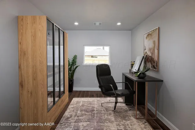 a view of a hallway with workspace and a window