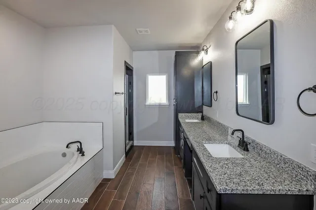 a bathroom with a granite countertop sink mirror and bathtub