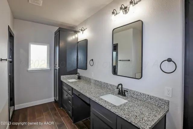 a bathroom with a granite countertop sink and a mirror