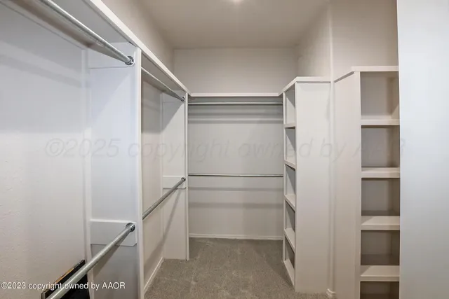 a view of walk in closet with empty racks