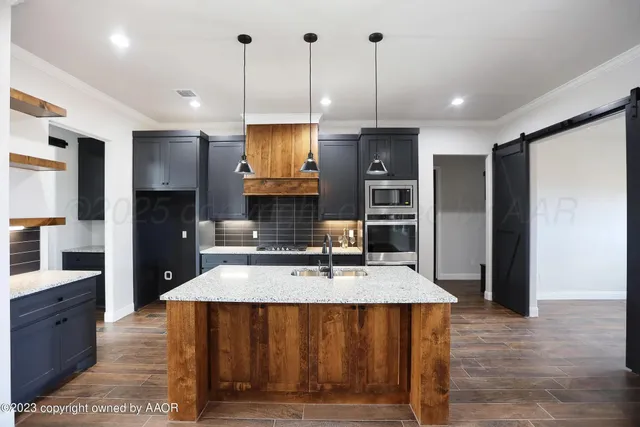 a kitchen with stainless steel appliances granite countertop a refrigerator a sink and a stove
