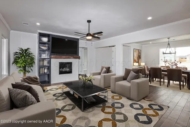 a living room with furniture a flat screen tv and a fireplace