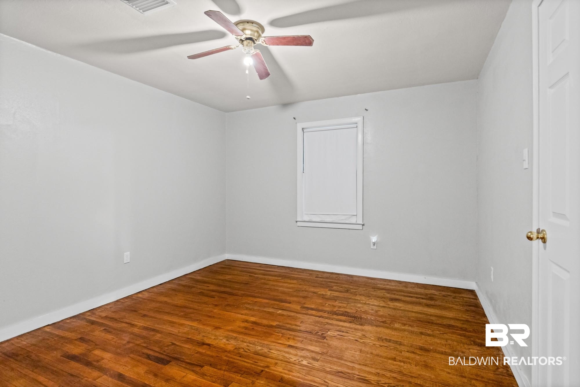 312 Sutherland Drive Mobile, AL 36611 - Photo 17 of 28 Unfurnished bedroom featuring wood-finish flooring, light gray wall paint, and white trim