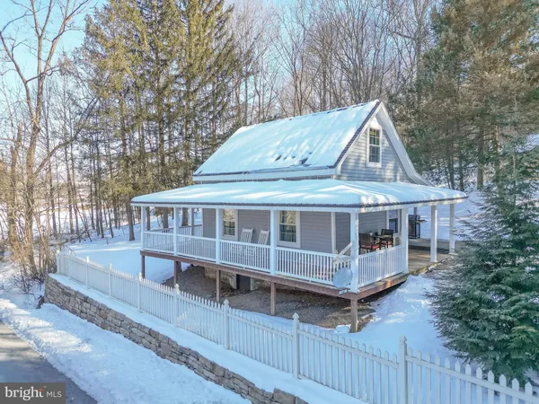 a view of a house with wooden deck and a backyard