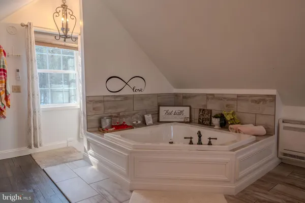 a white bath tub sitting next to a shower