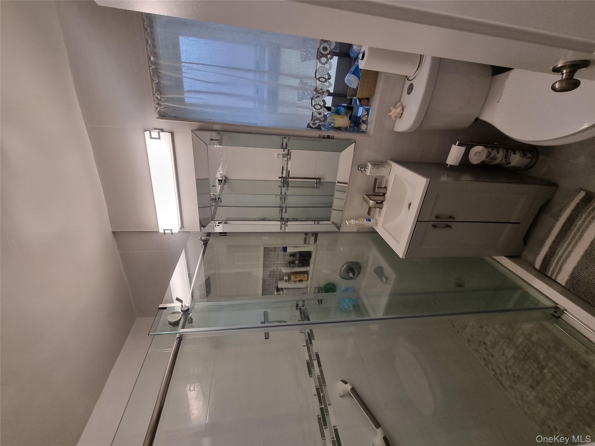 141-34 78th Avenue, Unit 1C Queens, NY 11367 - Photo 2 of 16 Full bath featuring a shower stall and vanity