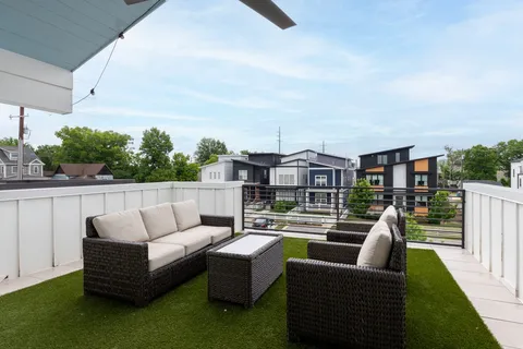 a view of roof deck with couches and potted plants