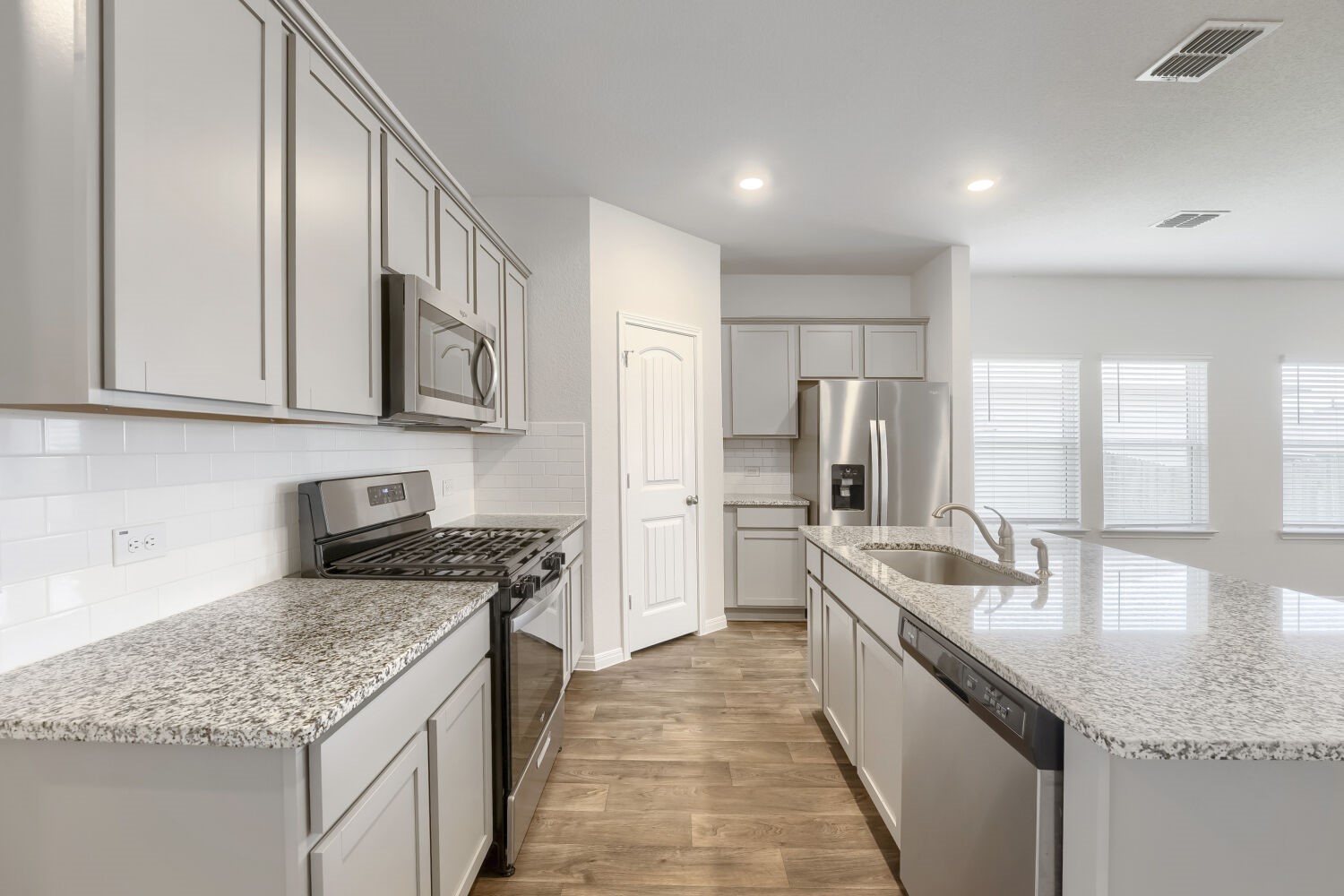 13507 Howser Trace Manor, TX 78653 - Photo 5 of 28 A contemporary kitchen features stainless steel appliances and abundant counter space.