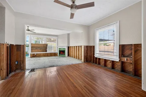 a view of a livingroom with wooden floor and staircase