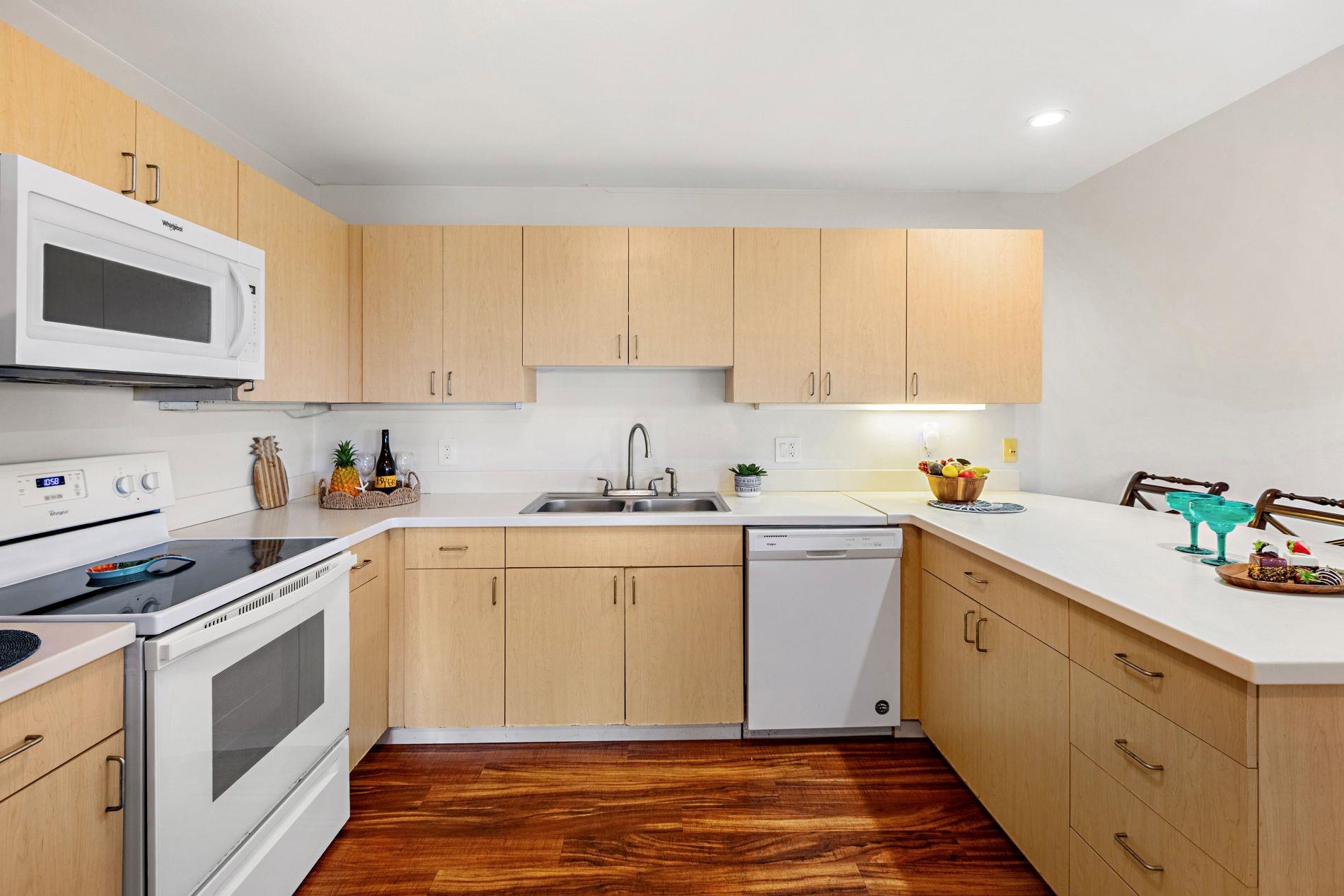 127 Punohu Lane, Unit 72 Lahaina, HI 96761 - Photo 31 of 43 a kitchen with granite countertop white cabinets and white appliances