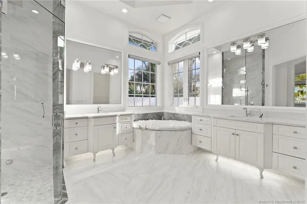a large bathroom with a large tub sink vanity and granite