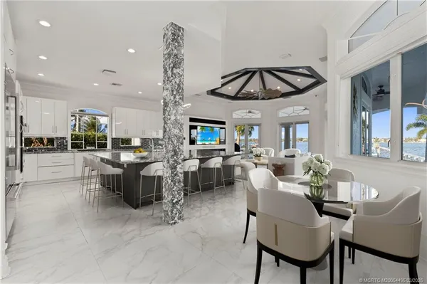 a living room with furniture a chandelier and a view of kitchen
