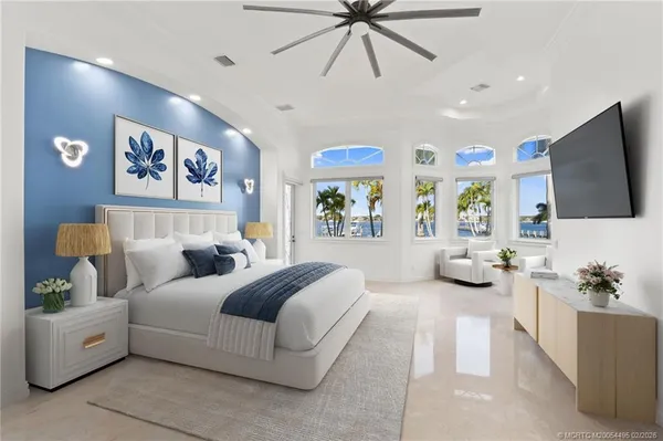 a spacious bedroom with a large bed and a flat screen tv