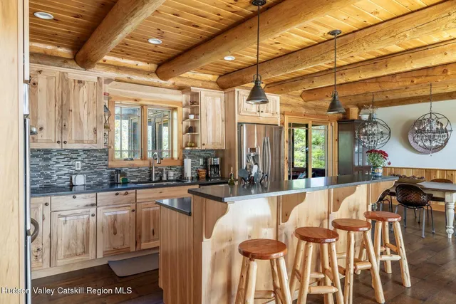 a kitchen with stainless steel appliances granite countertop a stove top oven a sink dishwasher a dining table and chairs with wooden floor