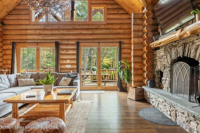 a living room with furniture floor to ceiling window and wooden floor