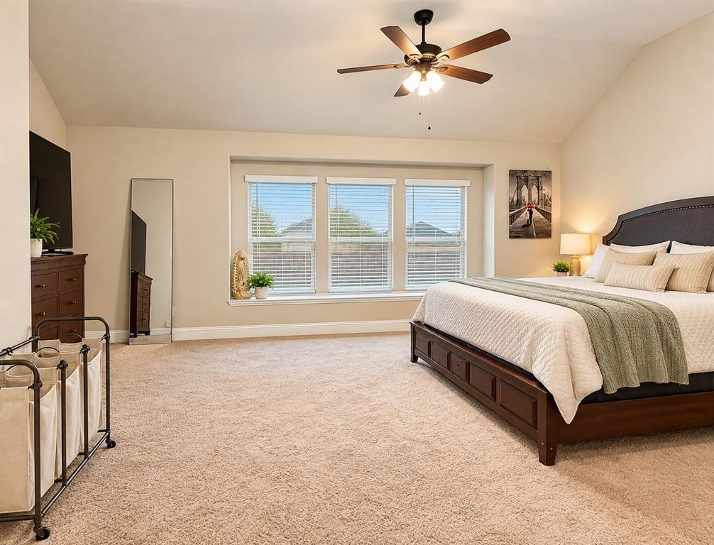 3301 Heathrow Road Mesquite, TX 75181 - Photo 16 of 26 Vaulted ceiling with a ceiling fan, carpeted flooring, three large windows, and a built-in window ledge