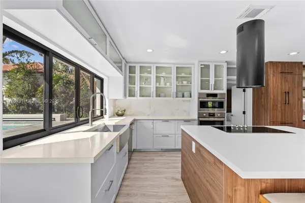 a kitchen with stainless steel appliances granite countertop a sink and stove top oven