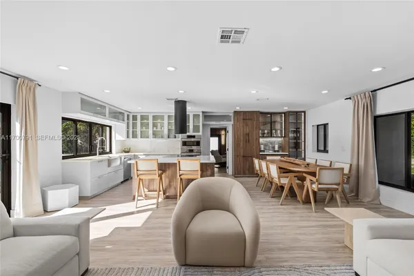 a living room with furniture wooden floor and a large window