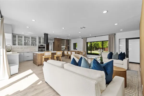 a dining room with furniture and a floor to ceiling window