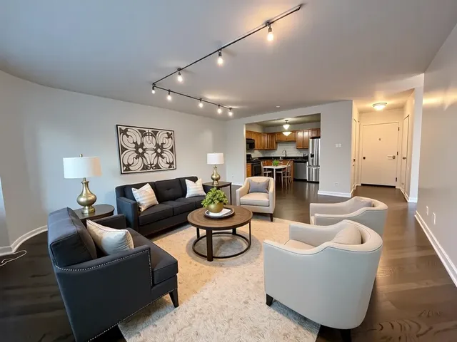 a kitchen with granite countertop a refrigerator a sink stainless steel appliances and cabinets