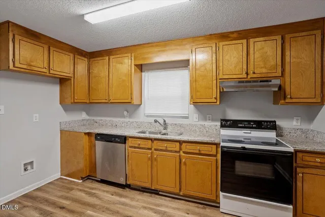 a kitchen with stainless steel appliances granite countertop wooden cabinets and a stove top oven